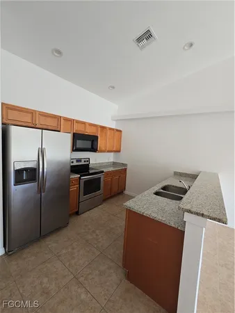 a kitchen with stainless steel appliances granite countertop a sink a stove and a refrigerator