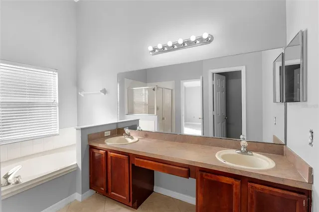 a bathroom with a granite countertop sink and a bathtub