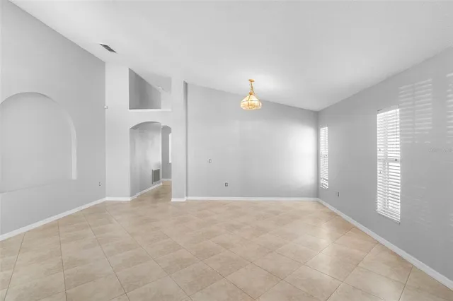 a view of empty room with window and wooden floor