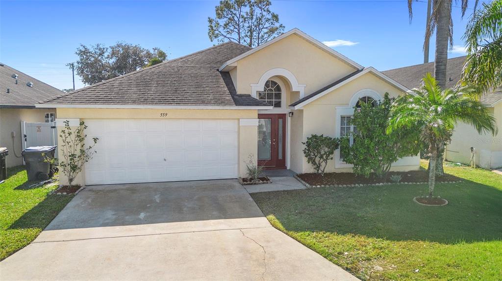 559 Saddle Ridge Drive Davenport, FL 33896 - Photo 4 of 42 a front view of a house with garden