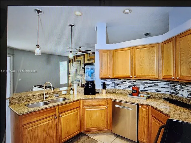 a kitchen with stainless steel appliances a sink a stove and a refrigerator