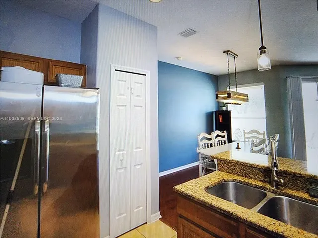 a kitchen with granite countertop a sink stainless steel appliances and cabinets