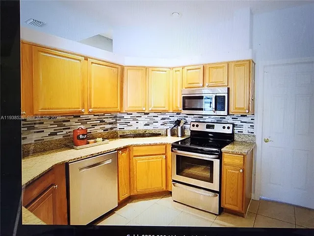 a kitchen with stainless steel appliances a stove a sink and a microwave