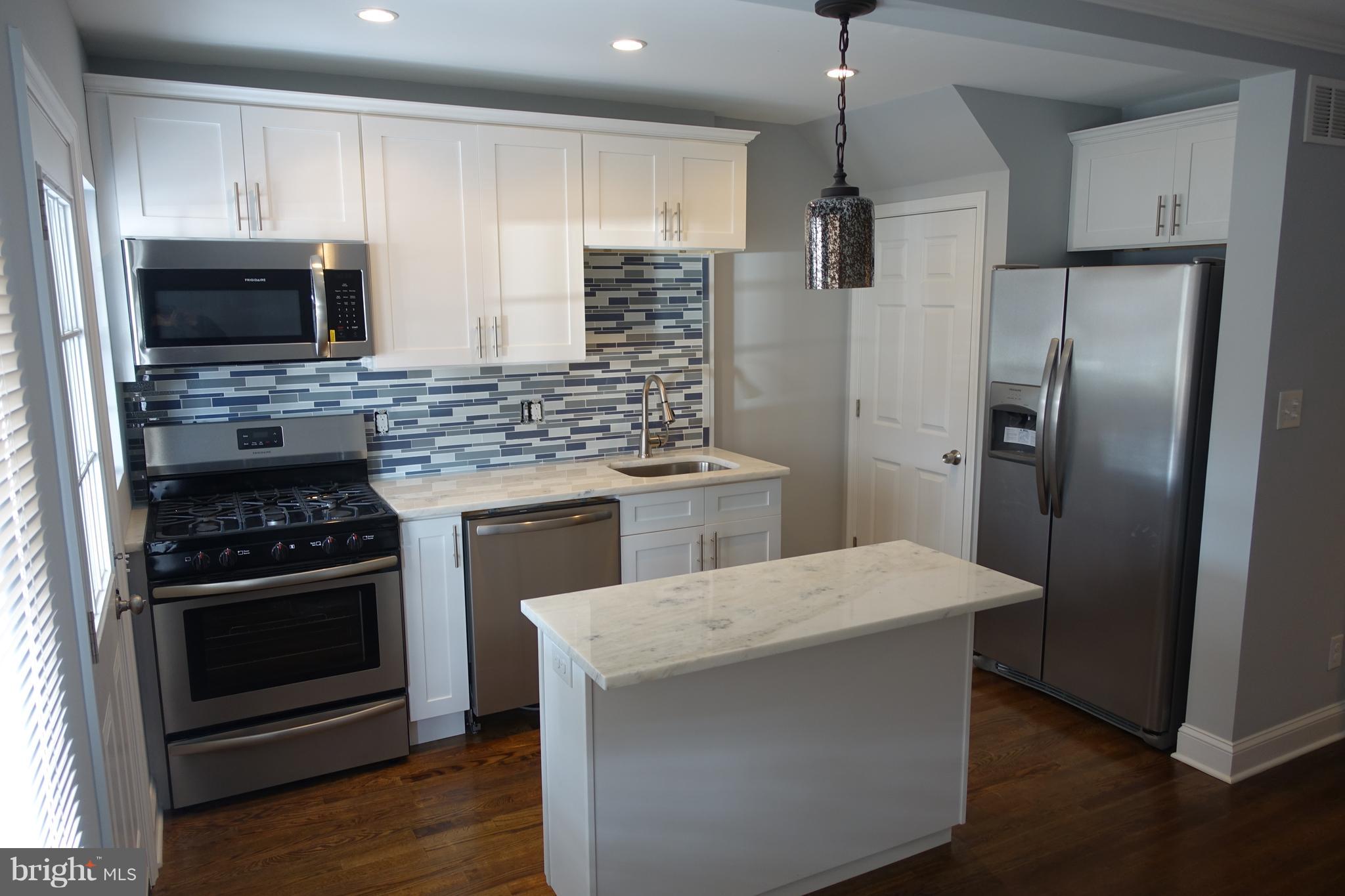 338 Grovethorn Road Baltimore, MD 21220 - Photo 5 of 24 a kitchen with stainless steel appliances kitchen island granite countertop a stove a refrigerator and a microwave