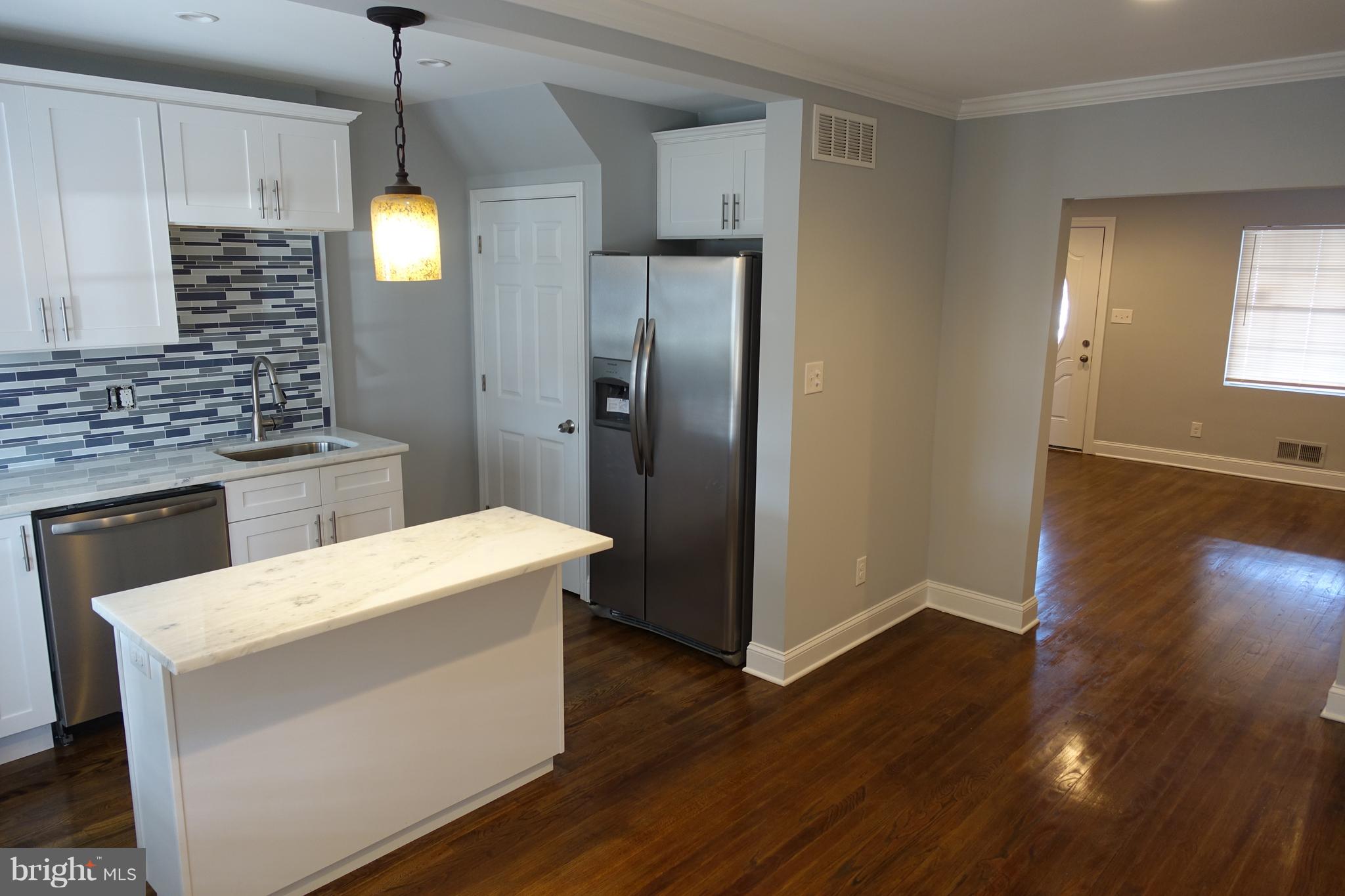 338 Grovethorn Road Baltimore, MD 21220 - Photo 6 of 24 a kitchen that has a sink a stove and a wooden floor