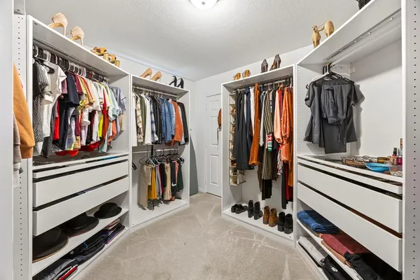 a view of walk in closet with clothes and shoes