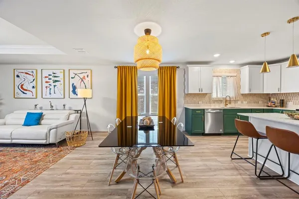 a living room with stainless steel appliances furniture and a chandelier