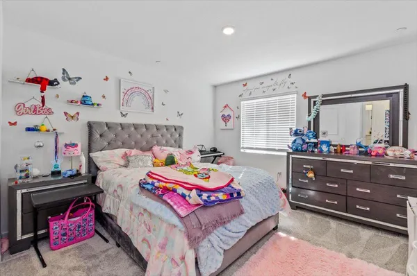 a bedroom with a bed a chair and books