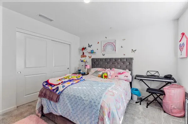 a bedroom with bed and paintings on the wall