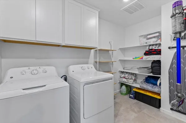 a kitchen with stainless steel appliances granite countertop a refrigerator a stove a sink and white cabinets