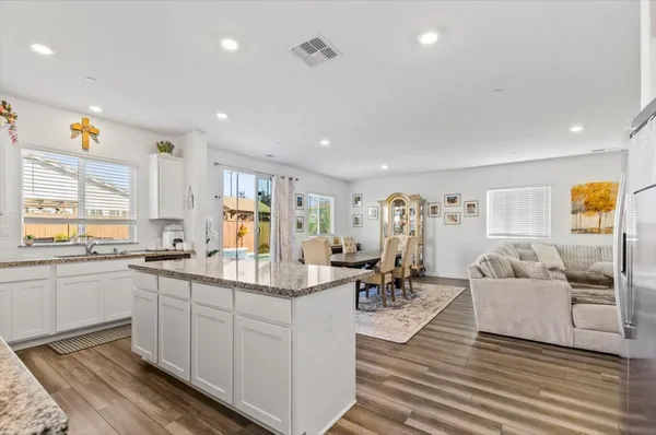 a kitchen with granite countertop white cabinets and white appliances