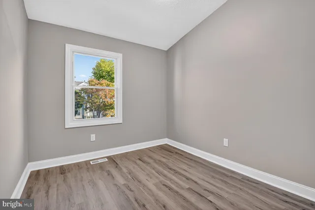 a view of an empty room with wooden floor