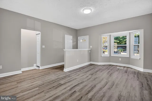 a view of empty room with wooden floor and fireplace