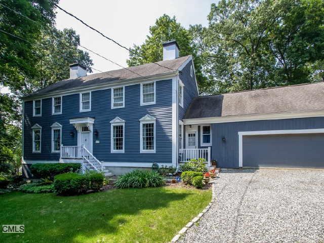 a front view of a house with yard and green space