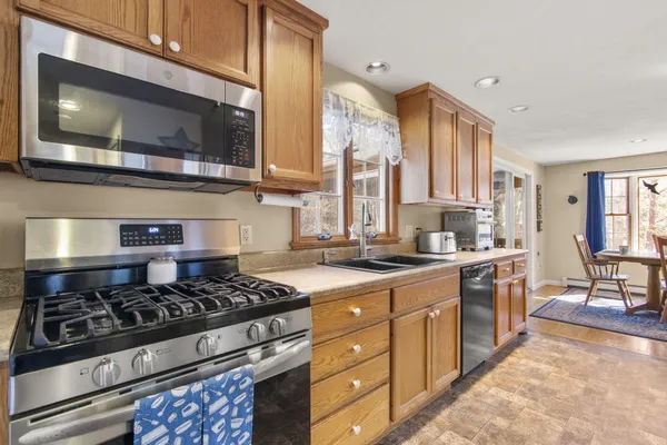 a kitchen with stainless steel appliances a stove a sink and a microwave