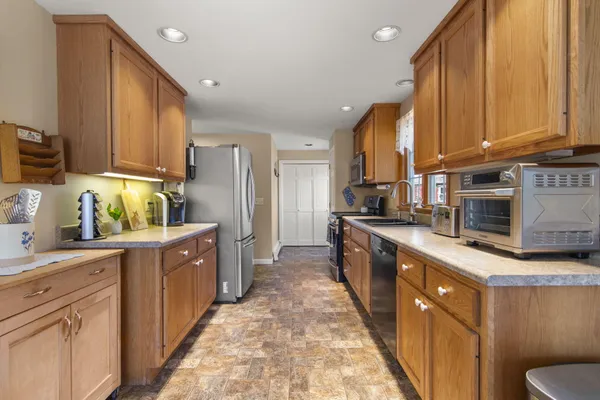 a large kitchen with stainless steel appliances granite countertop a stove a sink dishwasher and a refrigerator