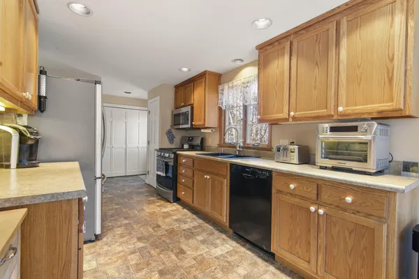 a kitchen with stainless steel appliances granite countertop a sink a stove and a refrigerator