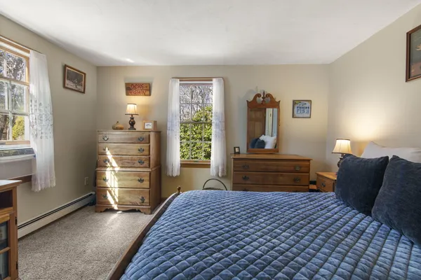 a bedroom with a bed and dresser with mirror