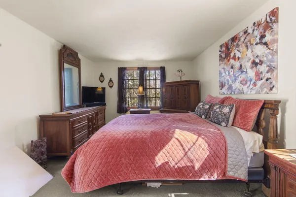 a bedroom with a bed and a flat screen tv