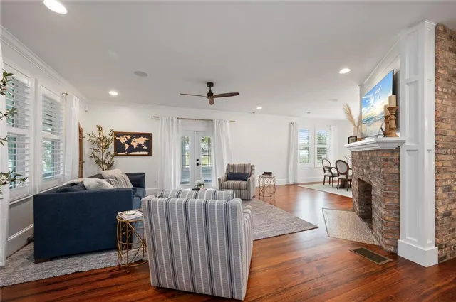 a large white kitchen with kitchen island a stove a sink a refrigerator and a dining table with wooden floor