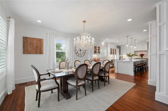 a kitchen with stainless steel appliances granite countertop a kitchen island hardwood floor sink and stove