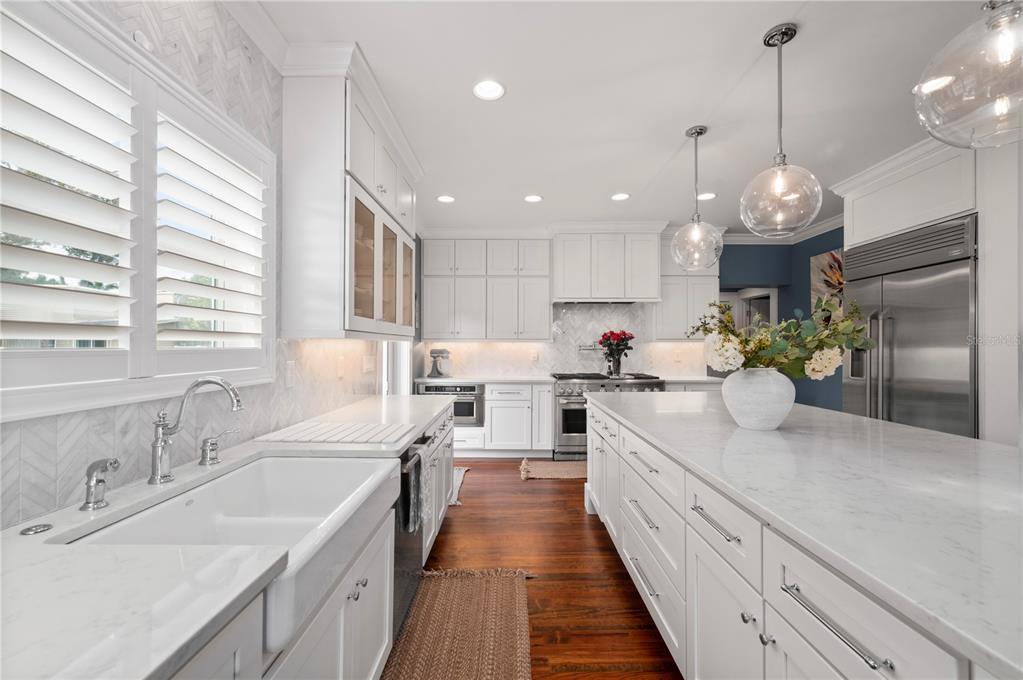 359 Gill Street Punta Gorda, FL 33950 - Photo 24 of 83 a large kitchen with kitchen island white cabinets and a chandelier