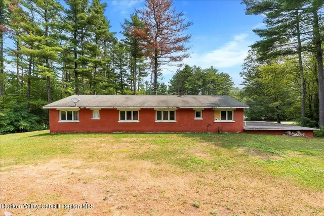 a view of a house with pool and sitting area