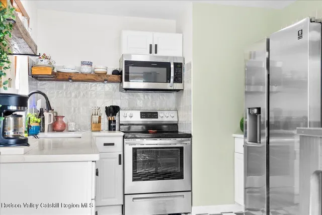 a kitchen with stainless steel appliances a stove microwave and a refrigerator