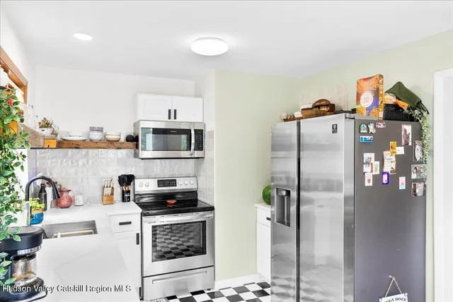 a kitchen with a refrigerator and a stove top oven