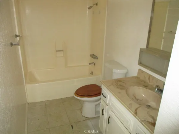 a bathroom with a granite countertop toilet and a sink