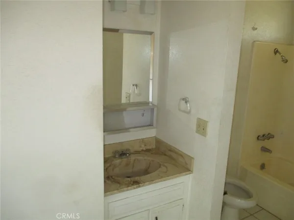 a bathroom with a granite countertop sink and shower