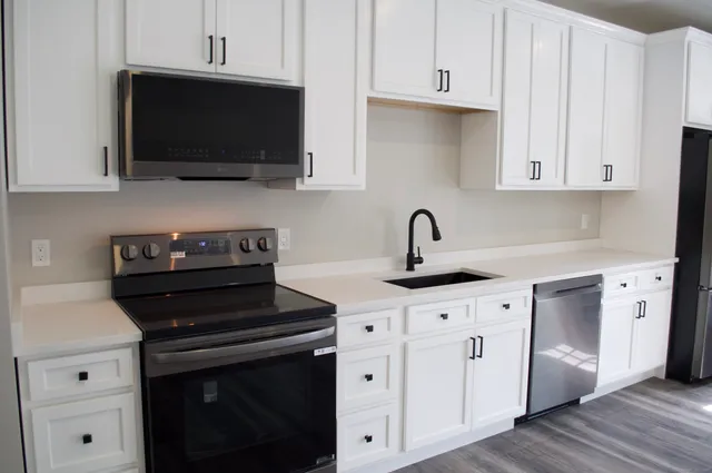 a kitchen with cabinets appliances and a sink