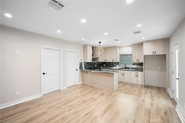 a large kitchen with cabinets wooden floor and stainless steel appliances