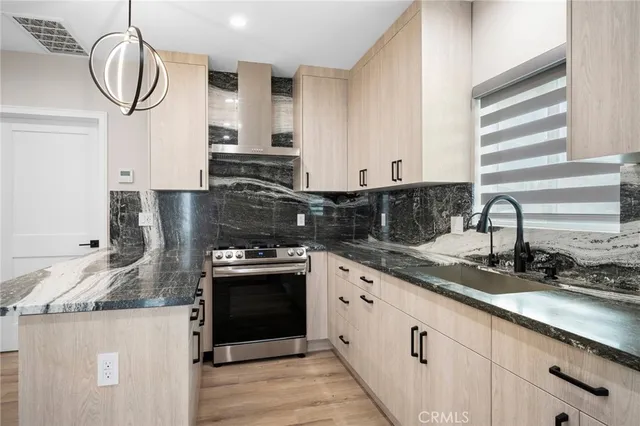 a kitchen with stainless steel appliances granite countertop a sink a stove and cabinets