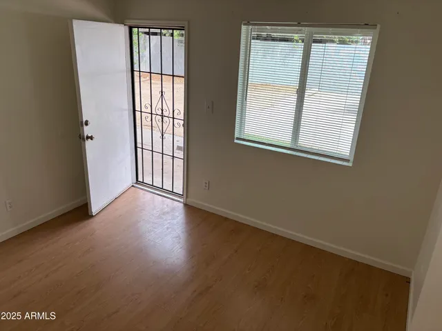 an empty room with wooden floor and windows