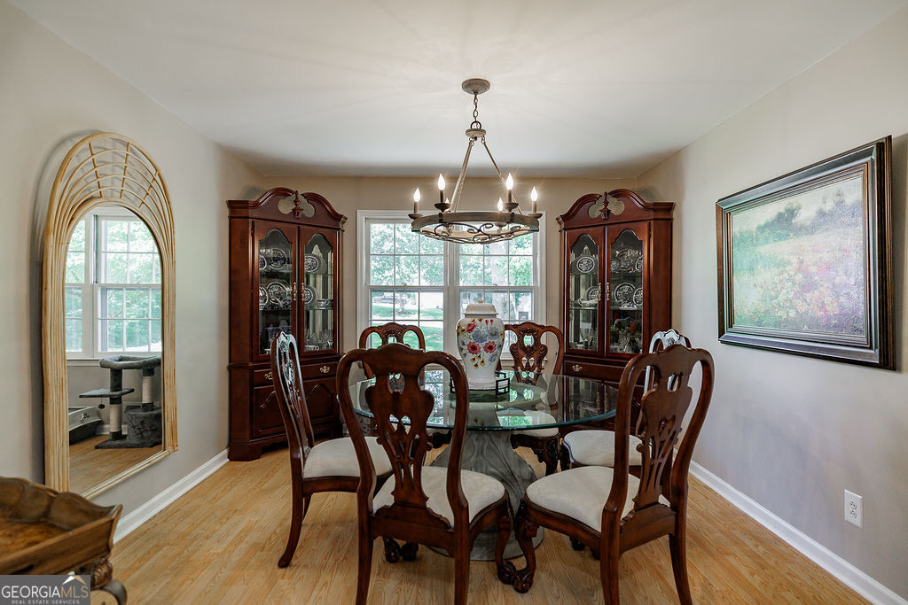 226 Baker Street Statham, GA 30666 - Photo 12 of 55 a dining room with furniture a chandelier and wooden floor