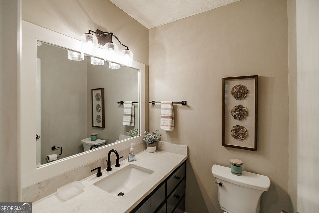 226 Baker Street Statham, GA 30666 - Photo 14 of 55 a bathroom with a sink and mirror with toilet
