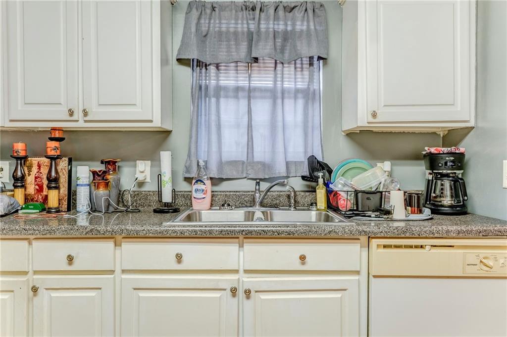 213 Iron Street Northwest Rome, GA 30165 - Photo 17 of 28 a kitchen with granite countertop white cabinets and white appliances