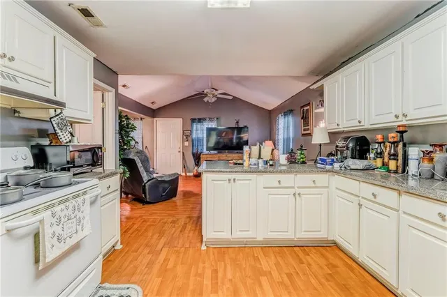 a kitchen with stainless steel appliances granite countertop a stove and white cabinets