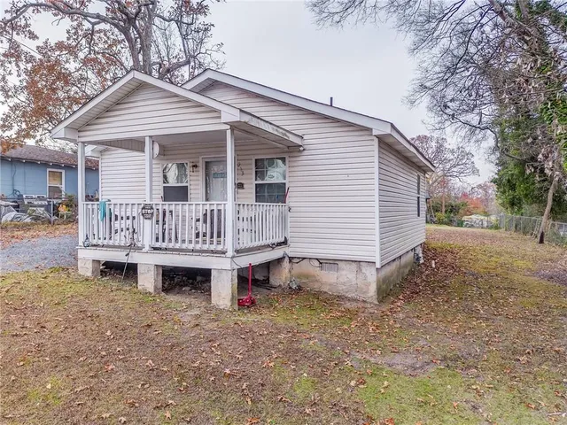 a view of a house with a yard and deck area
