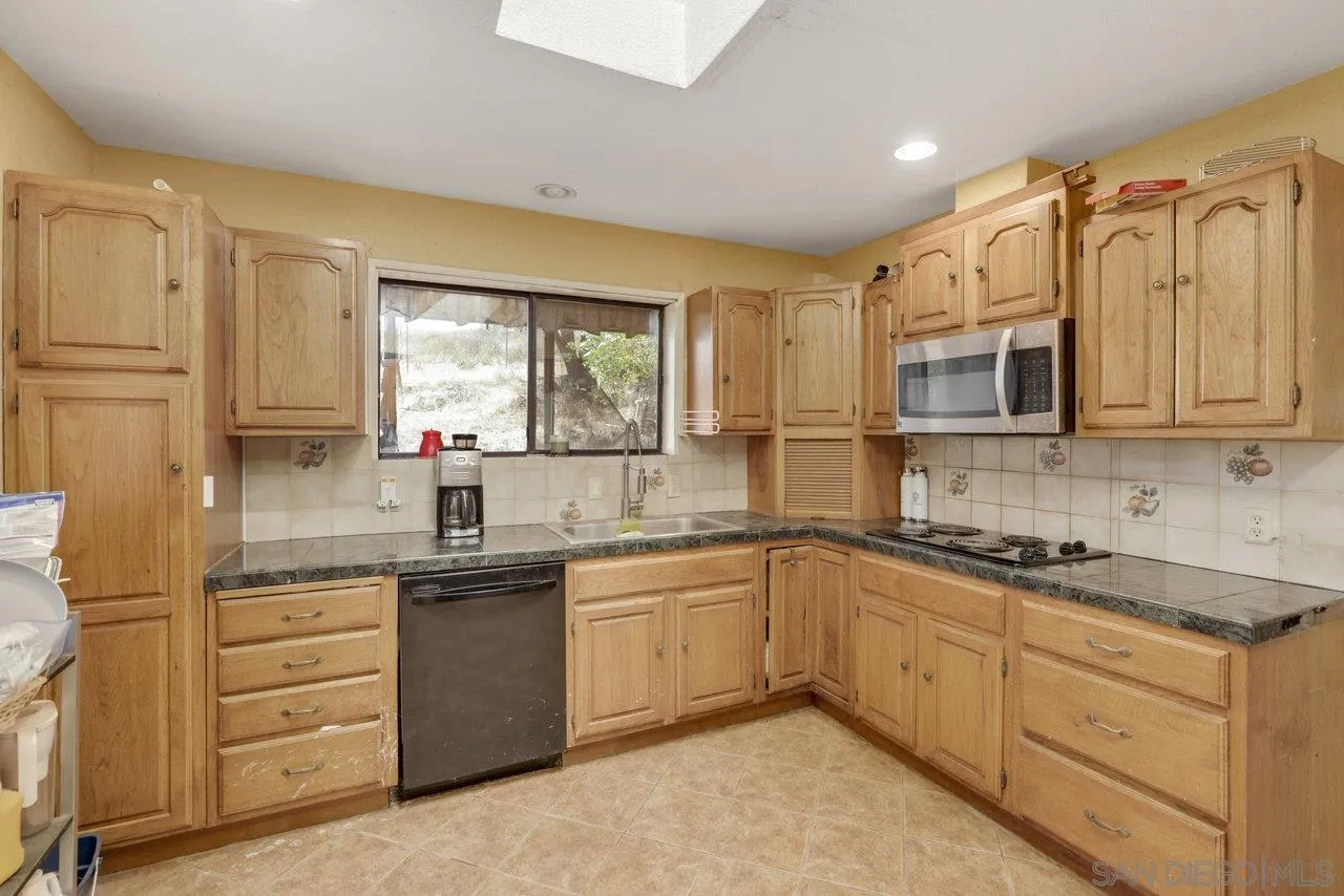 2212 Sonora Way Ramona, CA 92065 - Photo 6 of 29 a kitchen with granite countertop a sink stainless steel appliances and cabinets
