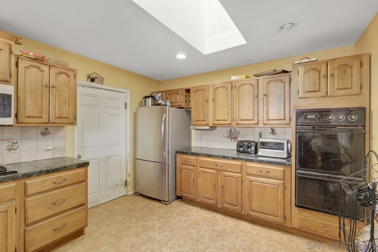 2212 Sonora Way Ramona, CA 92065 - Photo 7 of 29 a kitchen with white cabinets and stainless steel appliances
