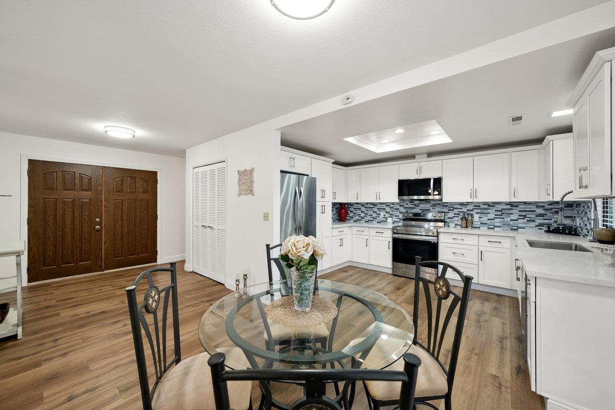 6561 Trinity Way Placerville, CA 95667 - Photo 32 of 58 a kitchen with granite countertop white cabinets refrigerator and chairs