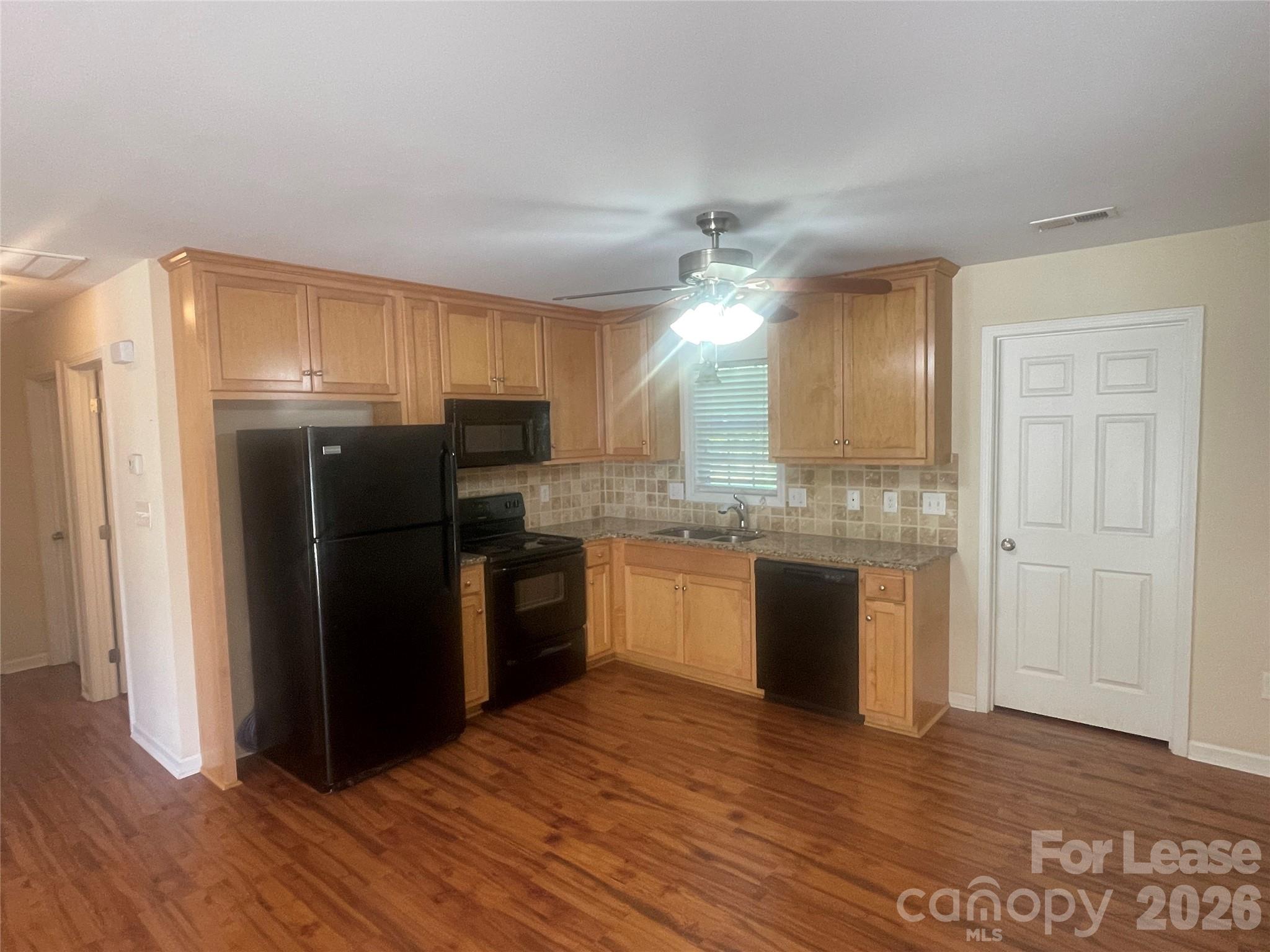 3791 Lee Moore Road Maiden, NC 28650 - Photo 4 of 11 a kitchen with granite countertop a refrigerator and wooden floor
