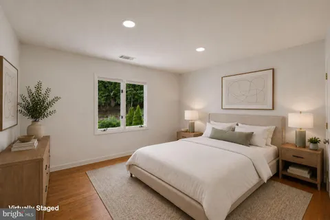 a bedroom with a bed mirror on dresser and a chandelier