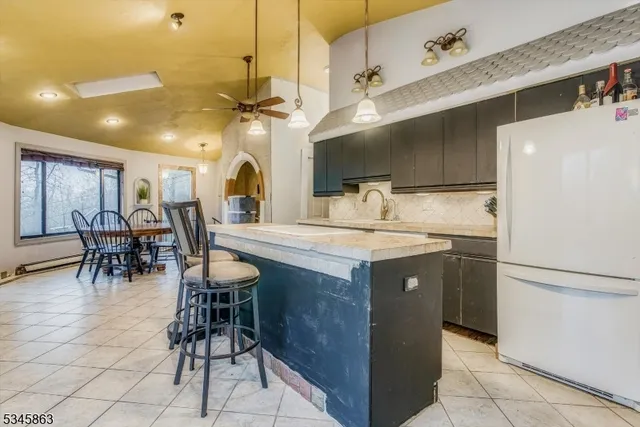 a kitchen with a refrigerator a table and chairs