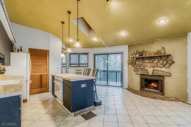 a kitchen with granite countertop a stove a sink and a refrigerator