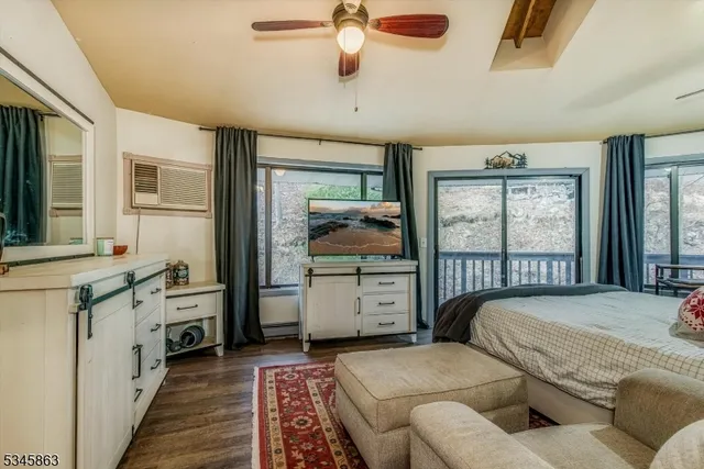 a bedroom with furniture and a large window