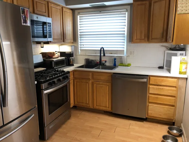 a kitchen with stainless steel appliances granite countertop a stove a sink and a refrigerator