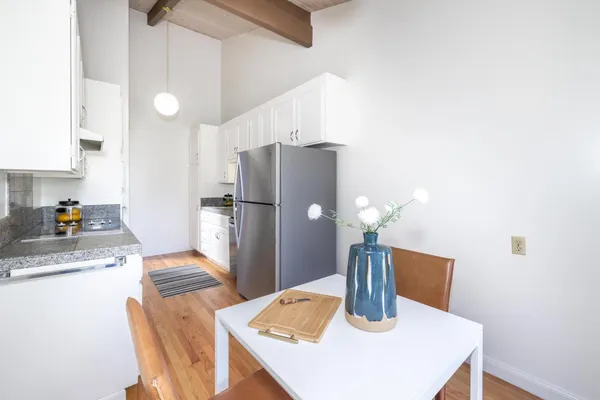 a kitchen with stainless steel appliances granite countertop a refrigerator a sink dishwasher with a dining table and chairs